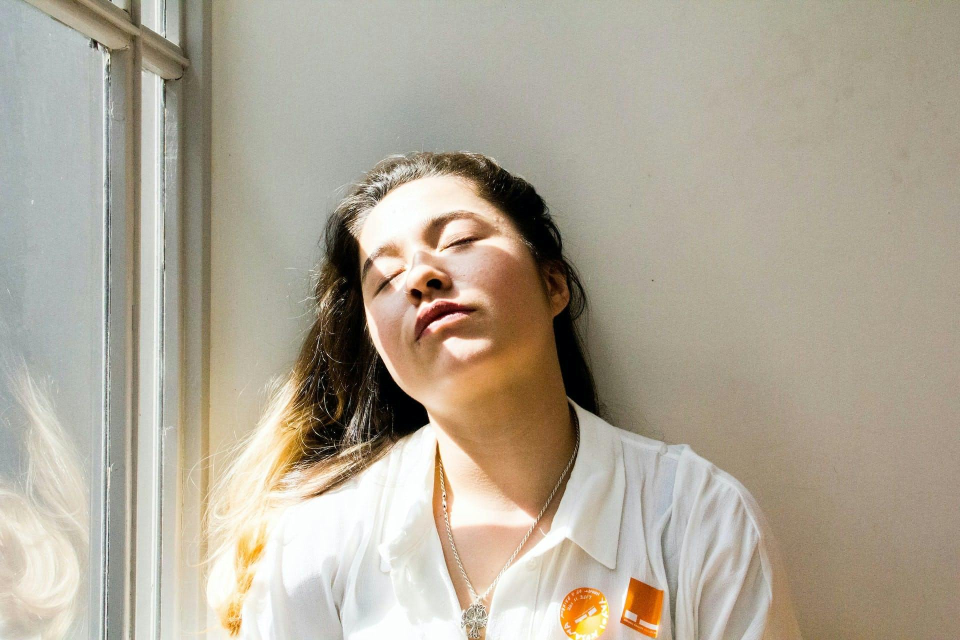 woman dozing off next to a sunny window