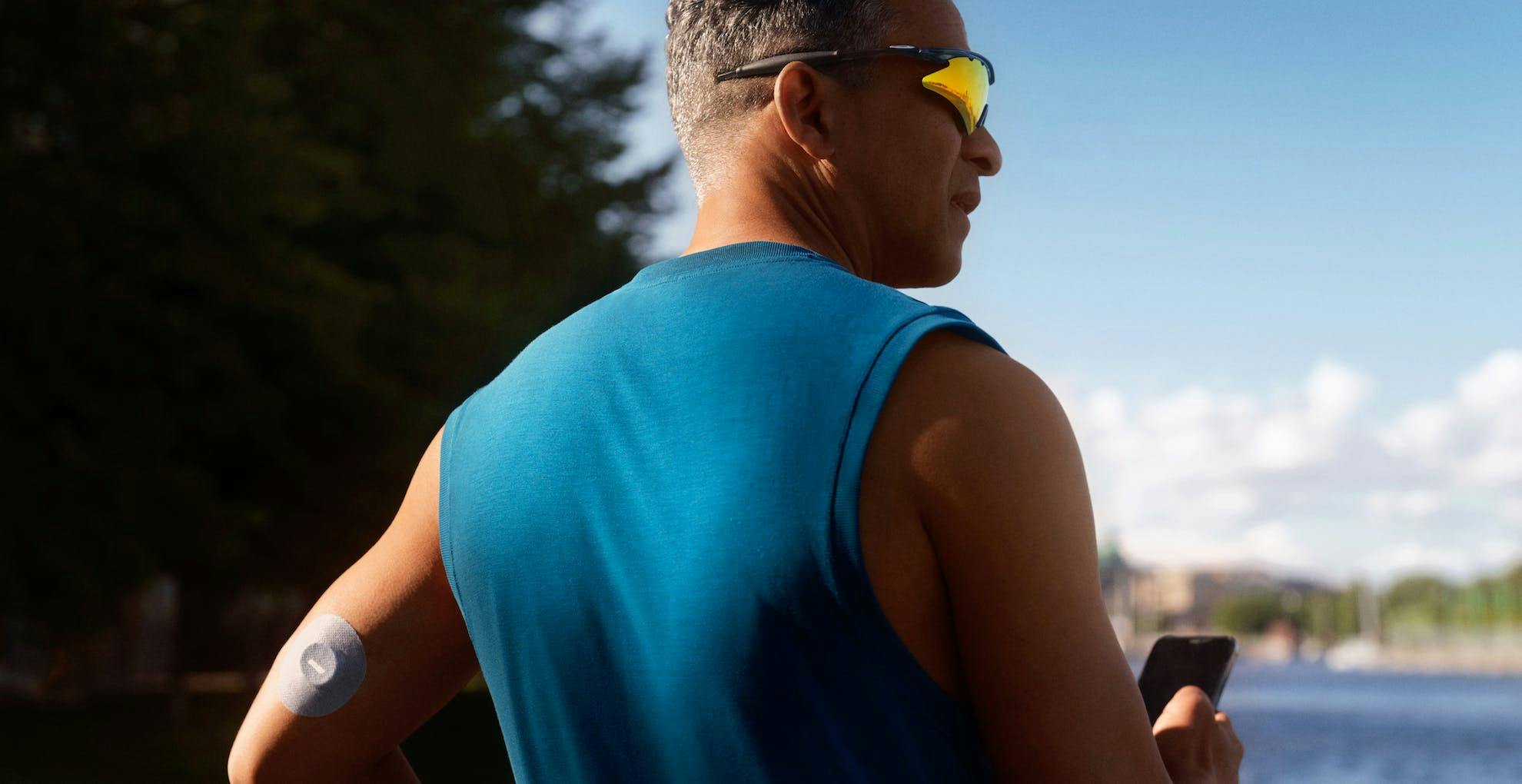 man wearing continuous glucose monitor preparing to go on an outdoor run
