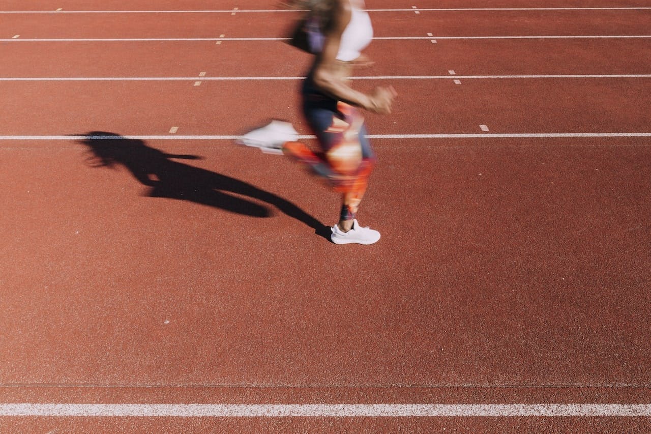 person doing metabolic conditioning sprint workout on an outdoor track