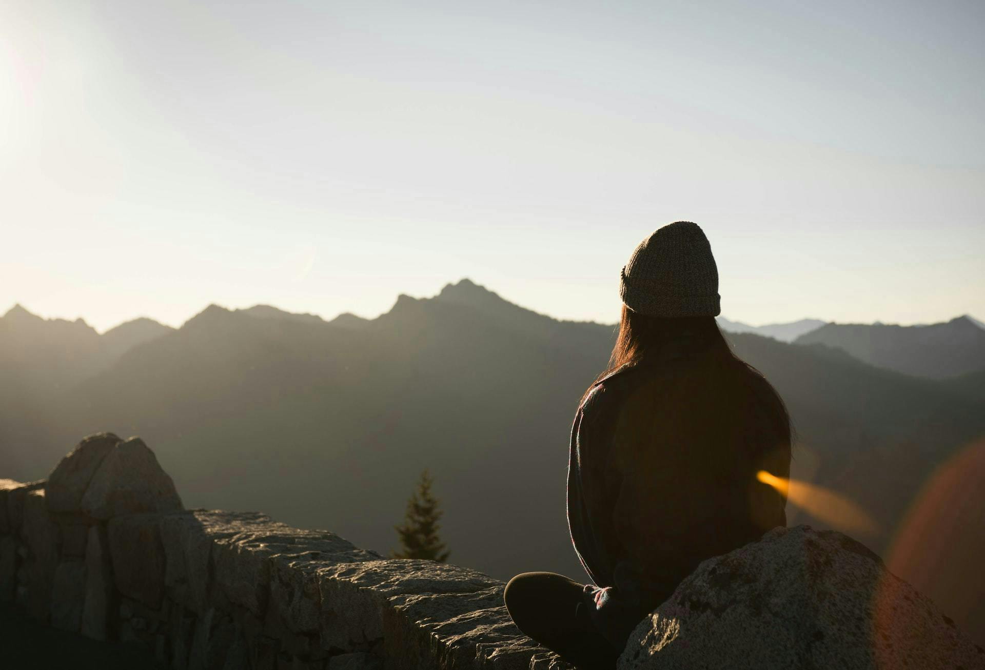 woman practicing breathwork and meditation in nature at sunrise