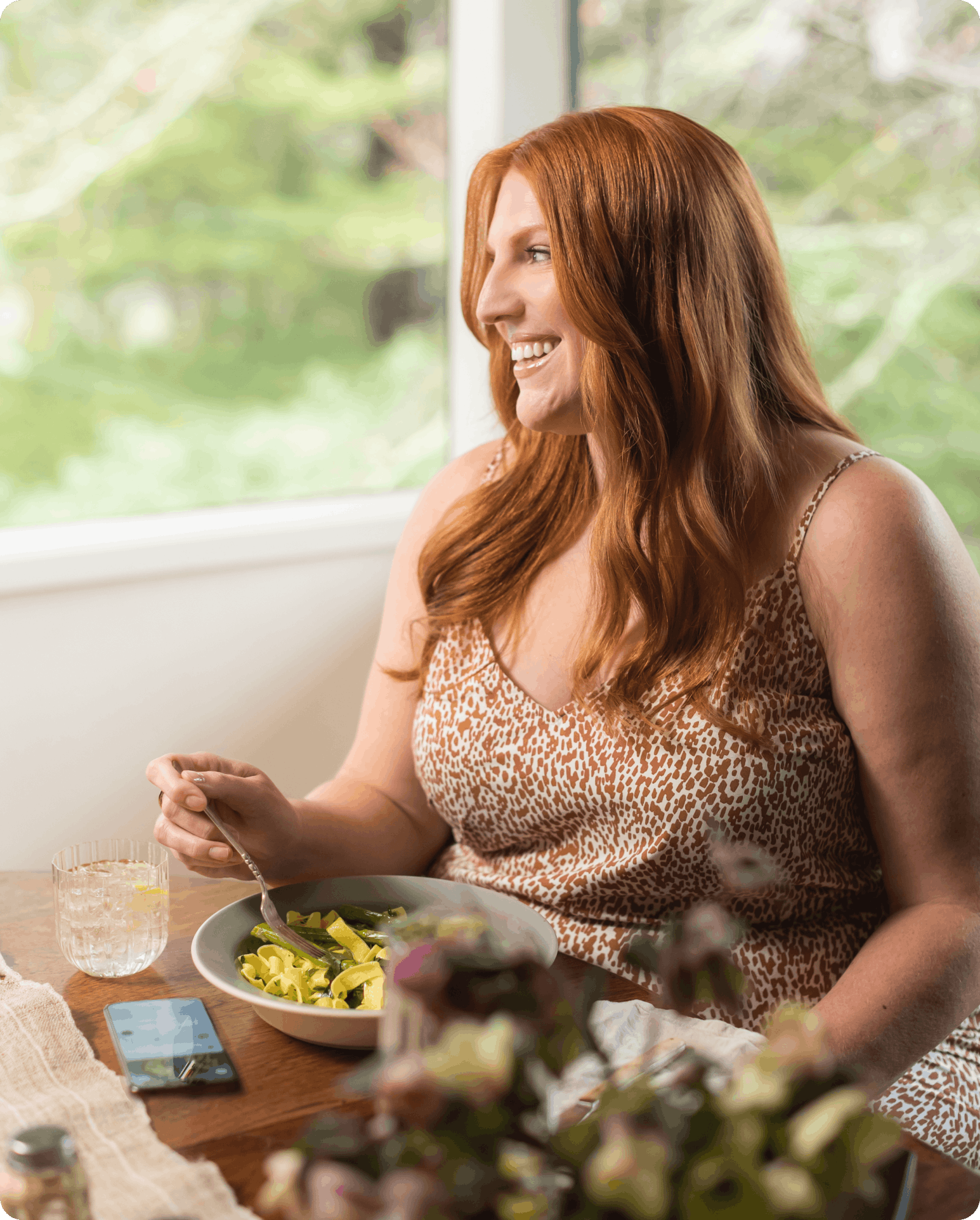 woman eating a salad by a window in natural light