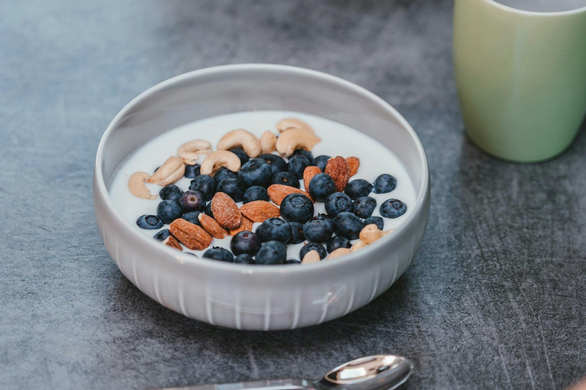 bowl of greek yogurt with blueberries almonds and cashews