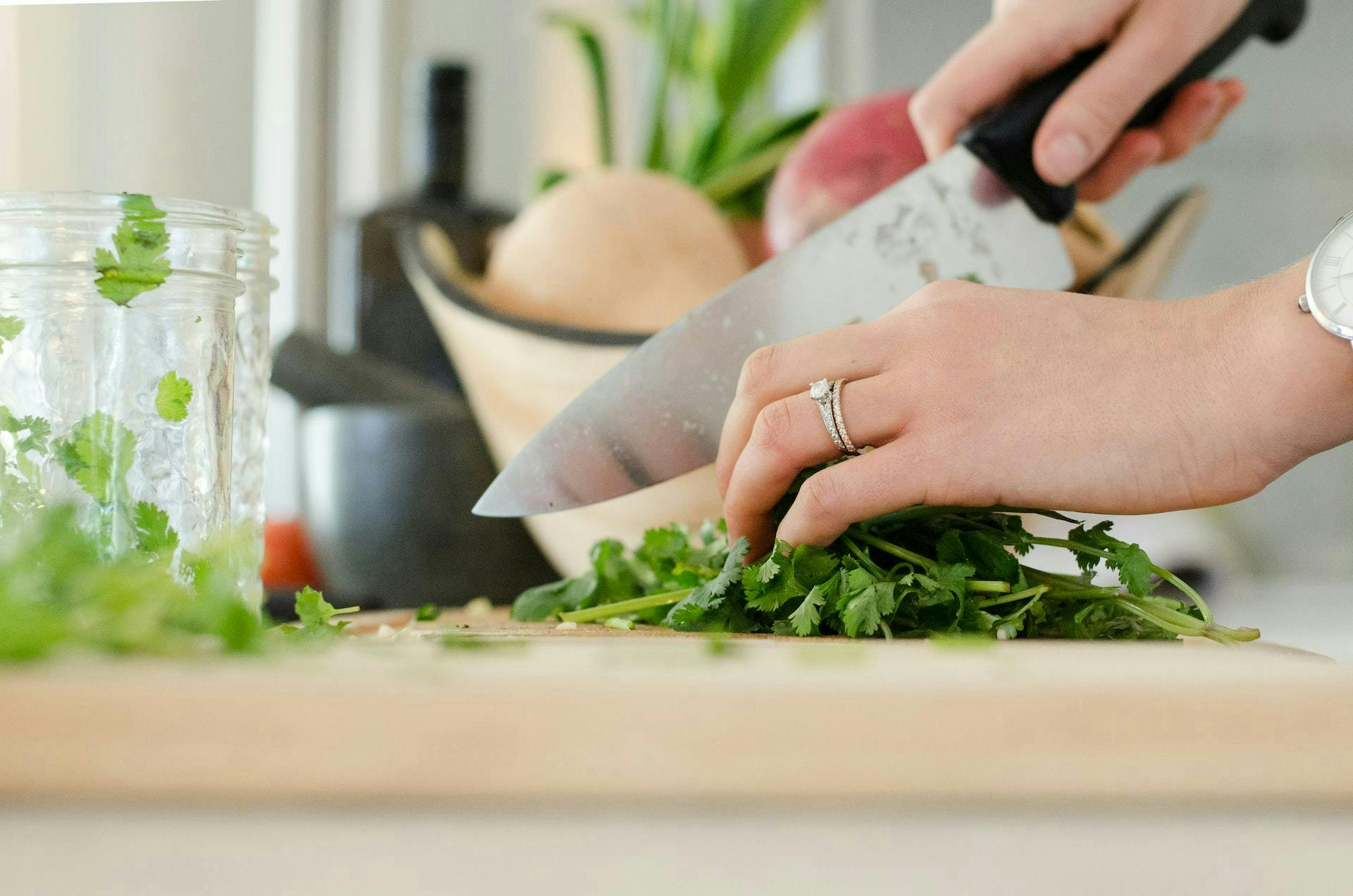 woman chopping parsley on a cutting board