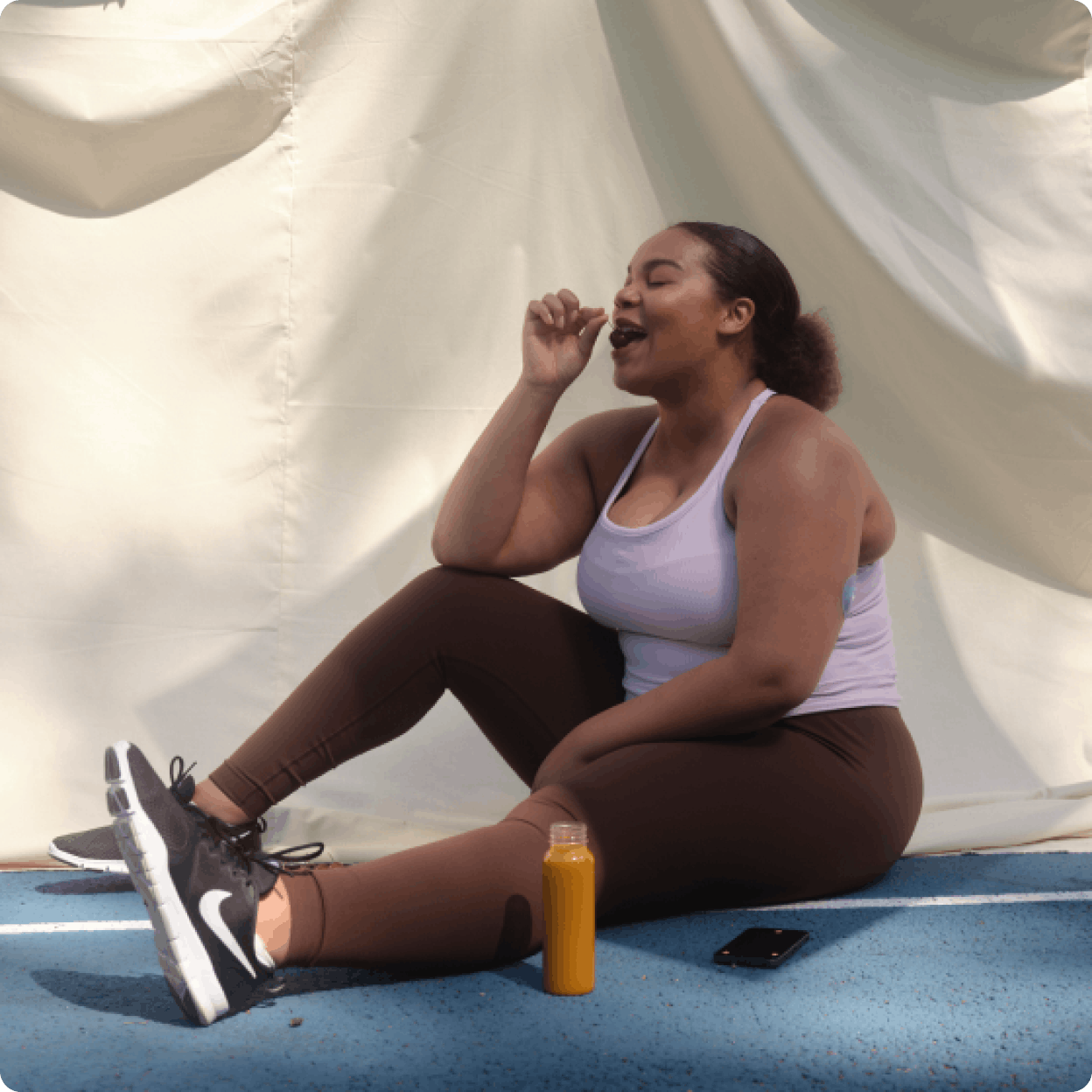 overweight woman eating snack in athletic clothes